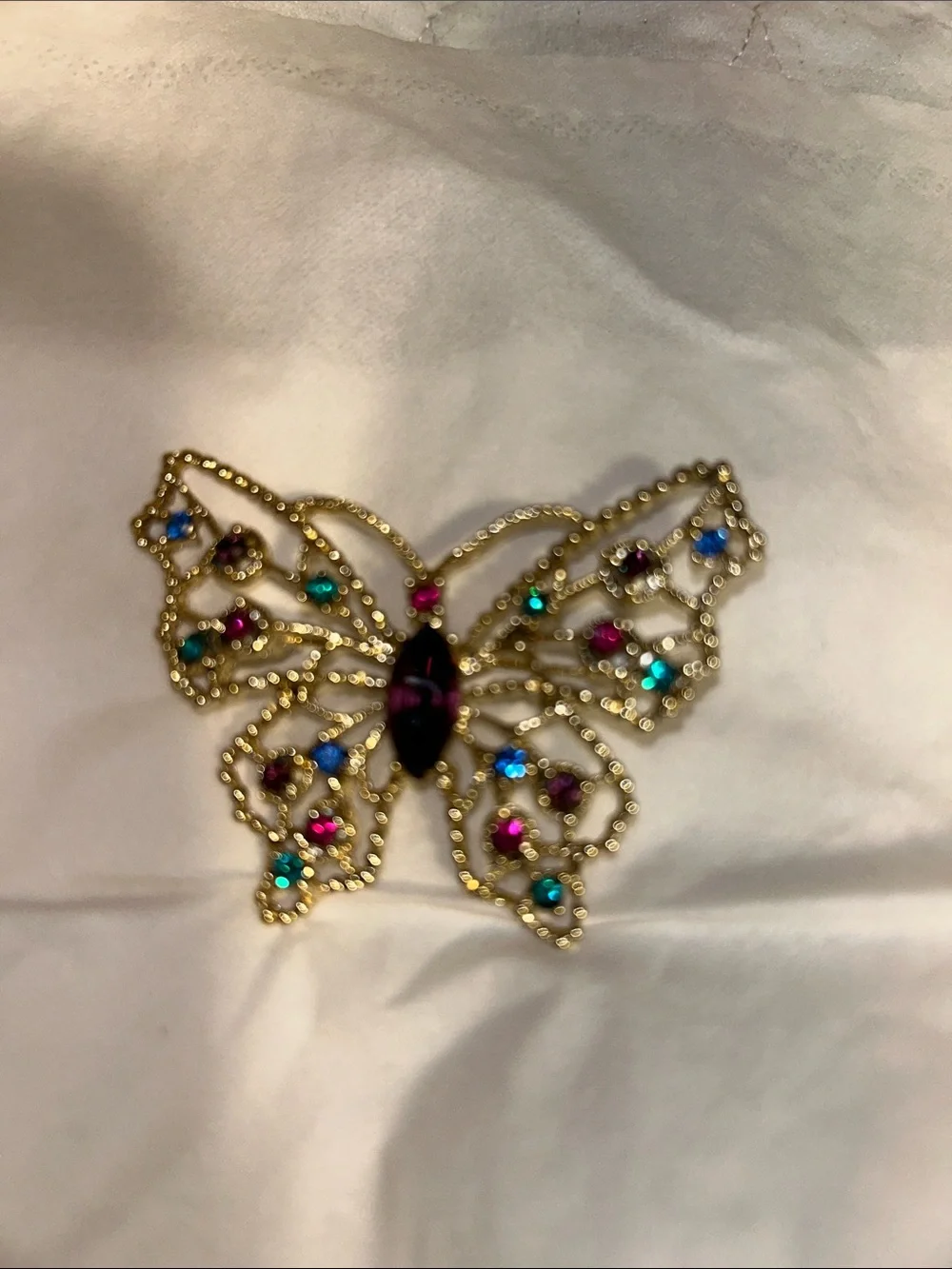 Dodds filigree butterfly brooch featuring a large amethyst-colored center stone